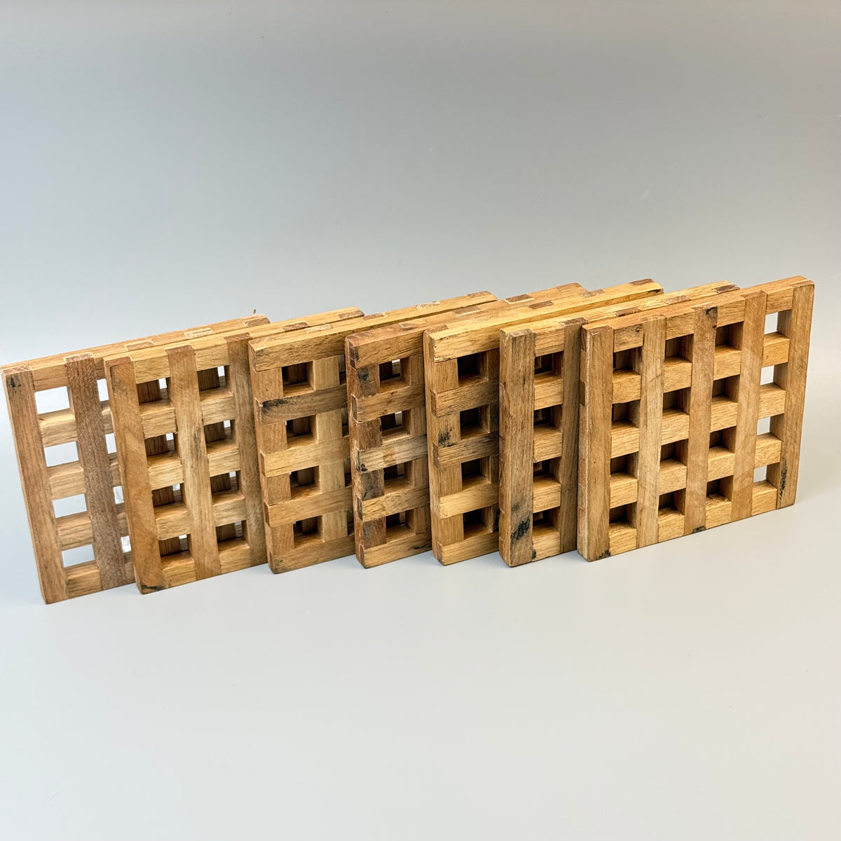 Vintage bordskånere i fingersamlet træ – sæt med 7 – 10,5 × 10,5 cm